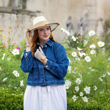 Woman wearing white leather and crochet back driving gloves, in the garden.