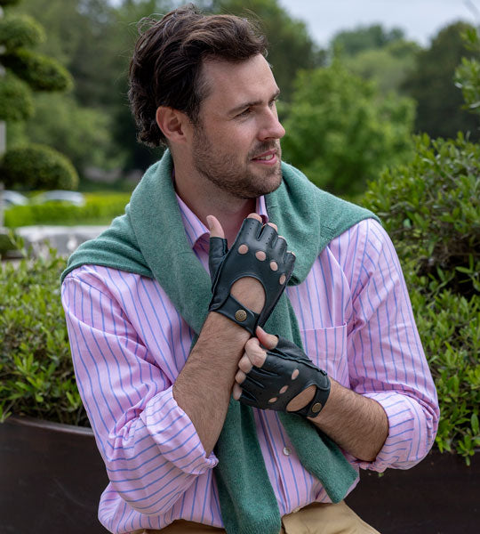 Man wearing fingerless leather driving gloves in british racing green