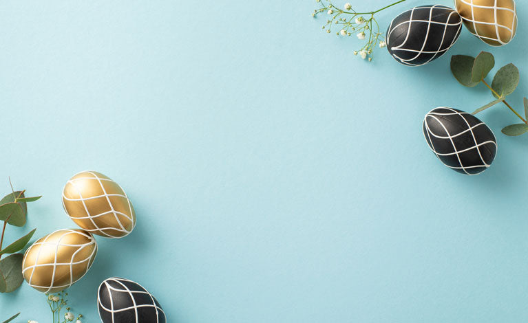 Blue background with black and gold easter eggs and flowers. 