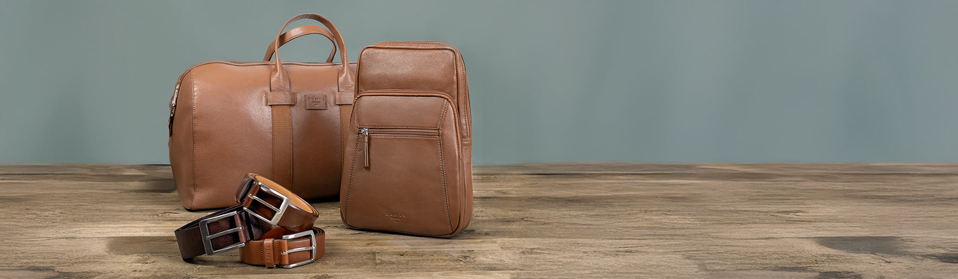 Knightsbridge leather bags in brown and belts on a wooden floor