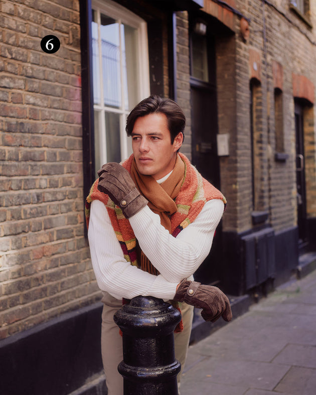 Man wearing touchscreen water resistant three point fleece lined suede gloves in brown in the city