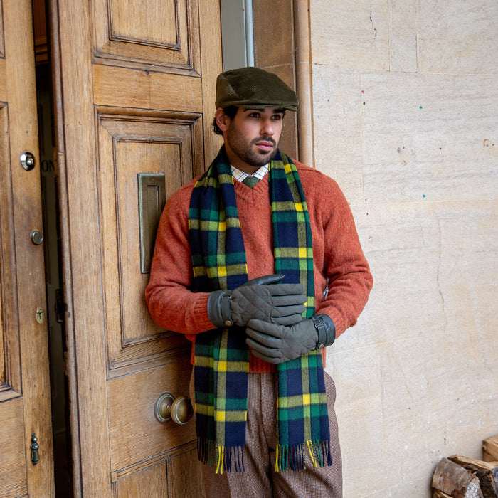 Man wearing a heritage cashmere scarf in dandelion with corduroy flat cap and leather gloves 