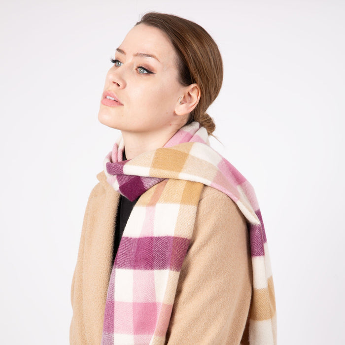 Woman wearing a Heritage plaid check cashmere scarf in aubergine