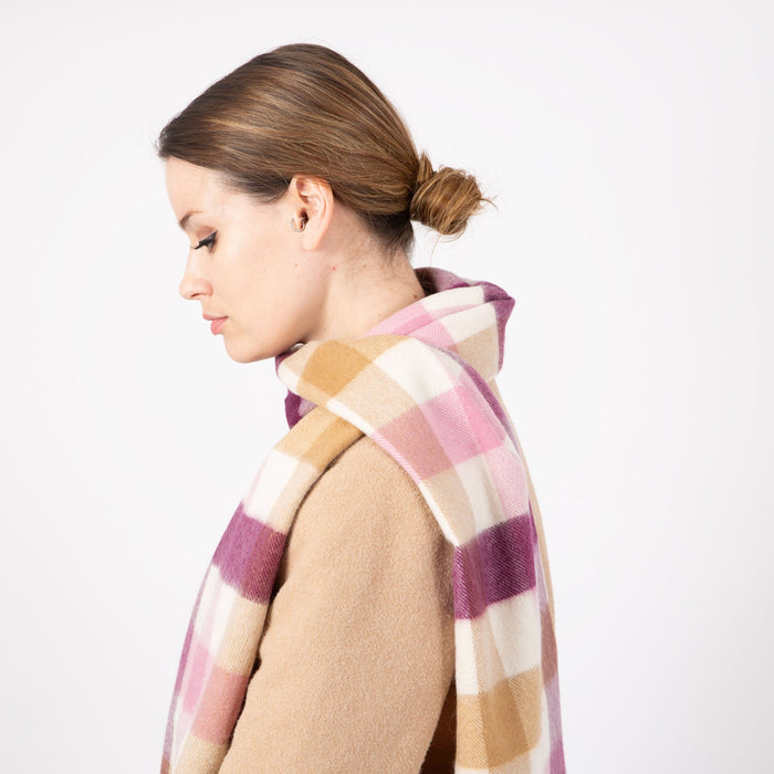 Woman wearing a Heritage plaid check cashmere scarf in aubergine