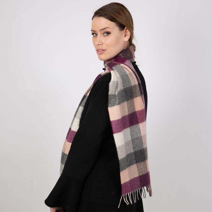Woman wearing a Heritage plaid check cashmere scarf in cassis