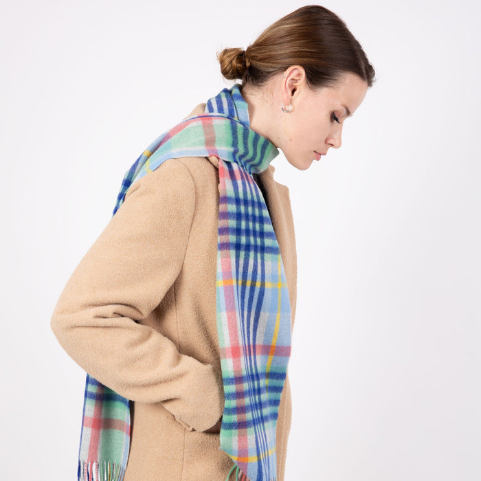 Woman wearing a Heritage plaid check cashmere scarf in coast