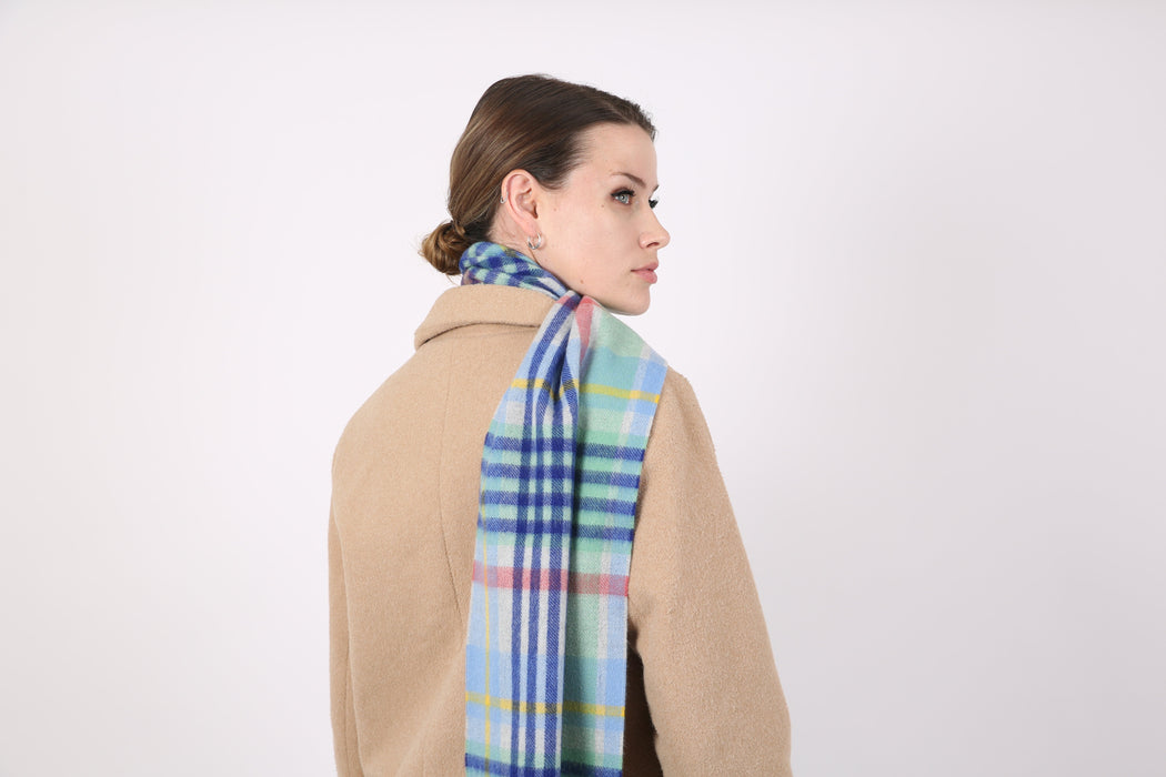 Woman wearing a Heritage plaid check cashmere scarf in coast