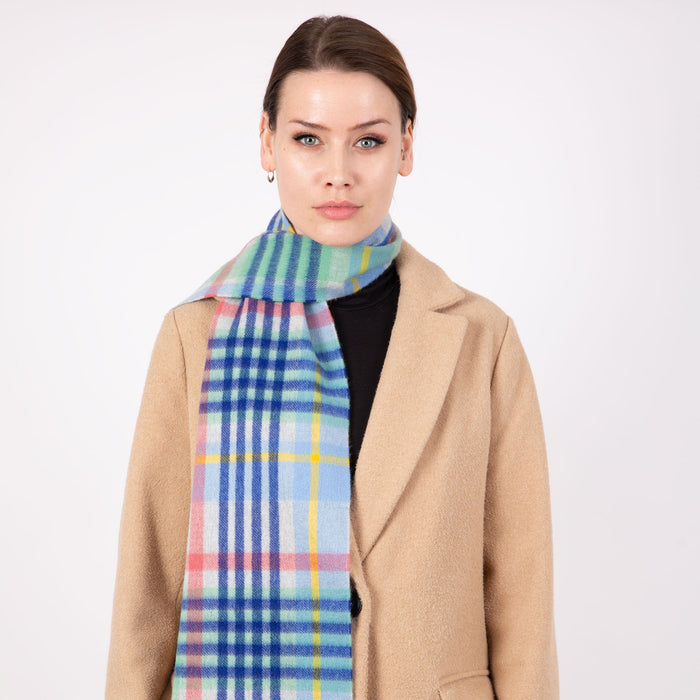 Woman wearing a Heritage plaid check cashmere scarf in coast