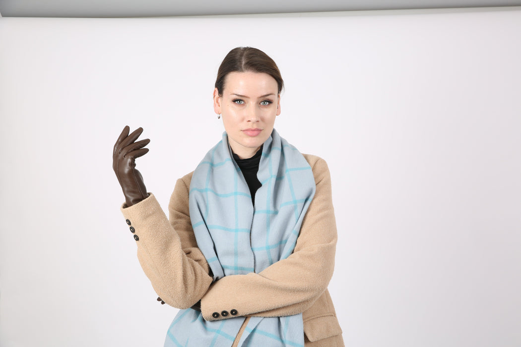 Woman wearing a Heritage plaid check cashmere scarf in duck egg