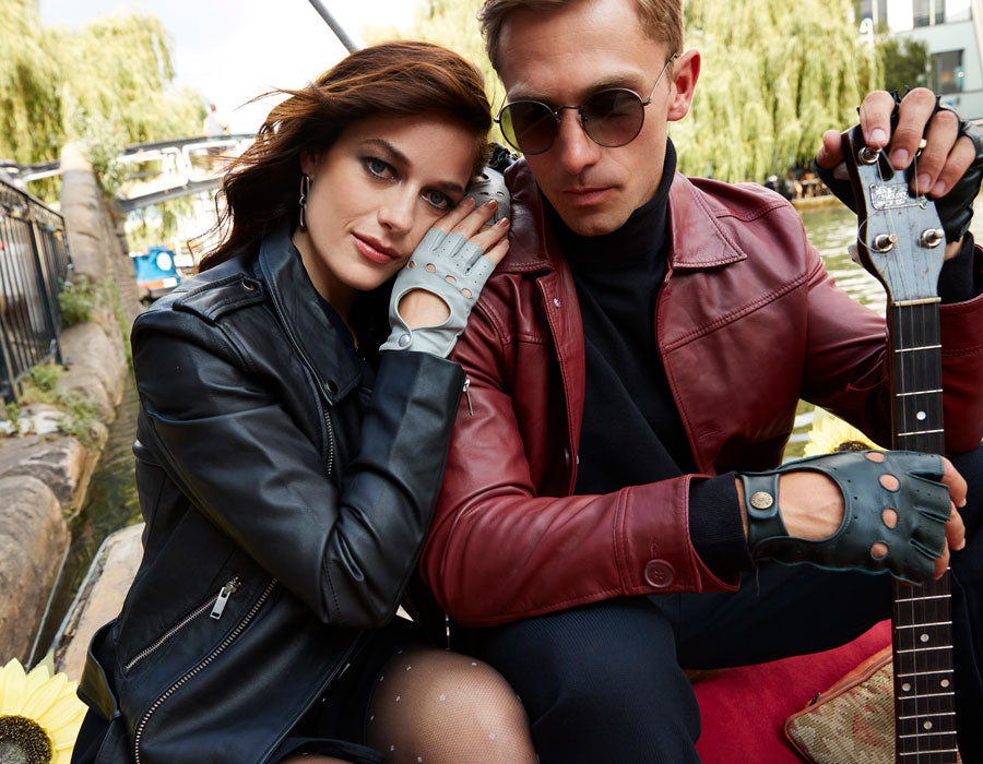 Man and woman on a boat, both wearing leather fingerless gloves. 