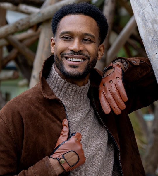man wearing leather driving gloves in brown outdoors
