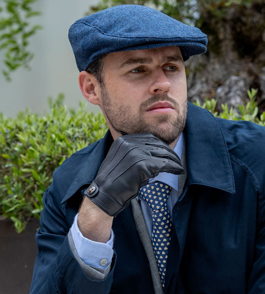 Man wearing tweed flat cap in navy outdoors