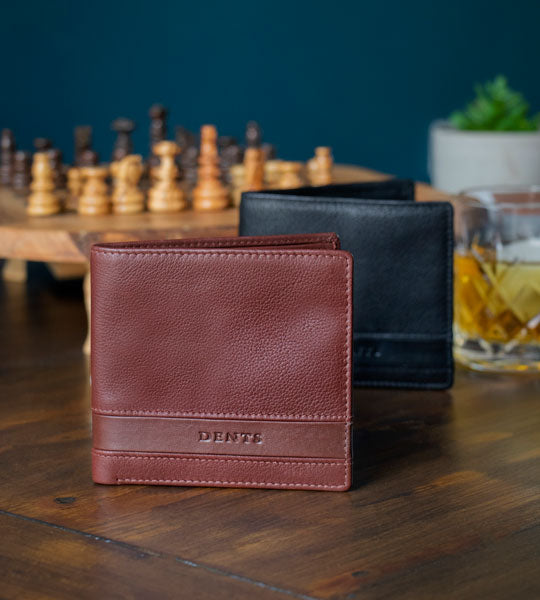 Men's leather wallets on a dark wooden table in black and brown.