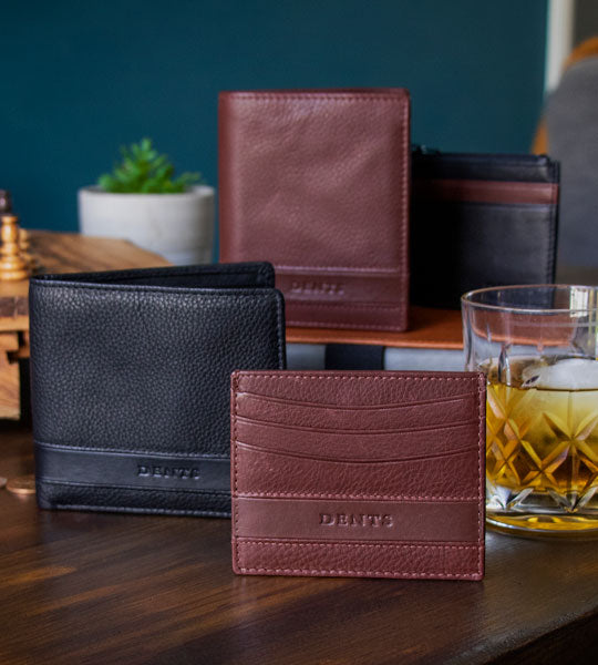 mens leather wallets in various colours and styles standing on a wooden table