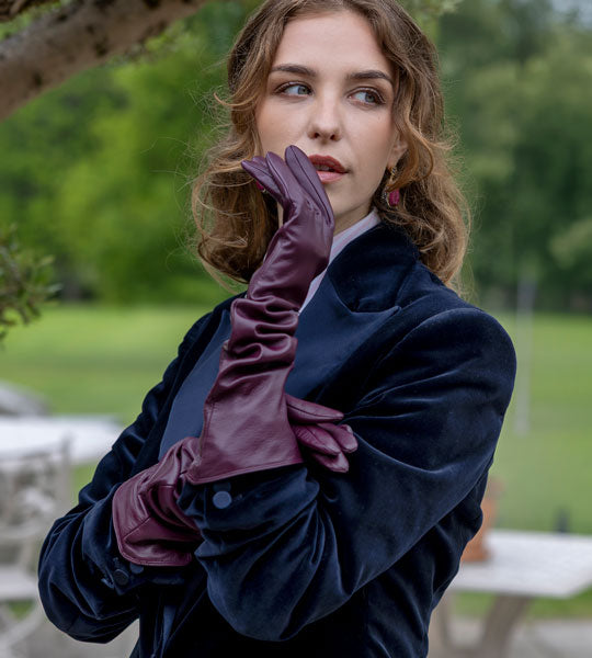 Woman wearing long leather gloves in burgundy outdoors