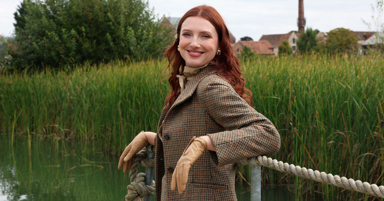 Woman wearing leather driving gloves in toffee whilst on a walk