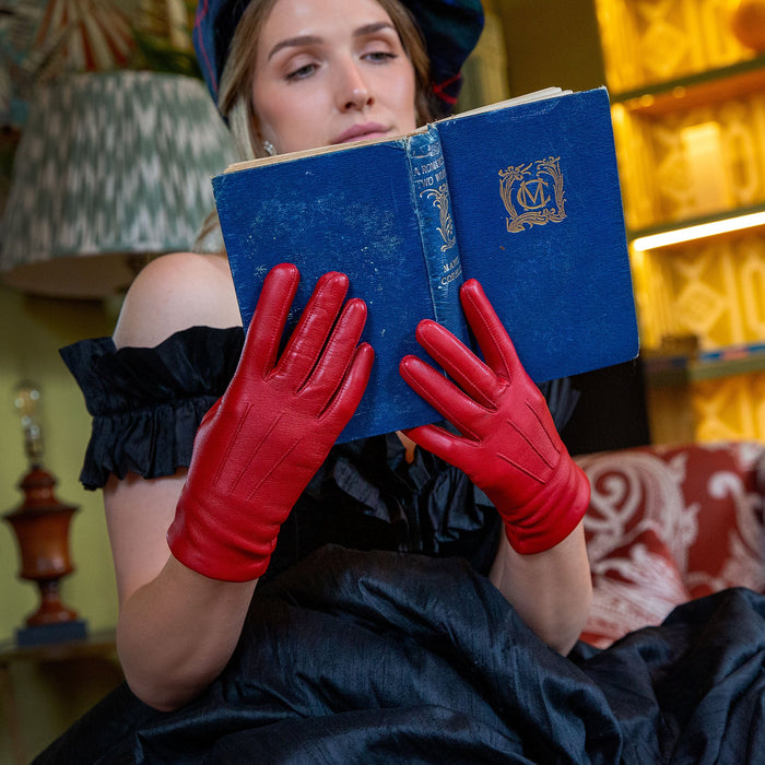 Woman wearing Women's Berry Three Point Lined Leather Gloves reading a book