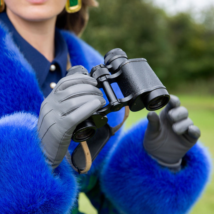 Woman wearing Women's Charcoal Three Point Lined Leather Gloves in a park with binoculars