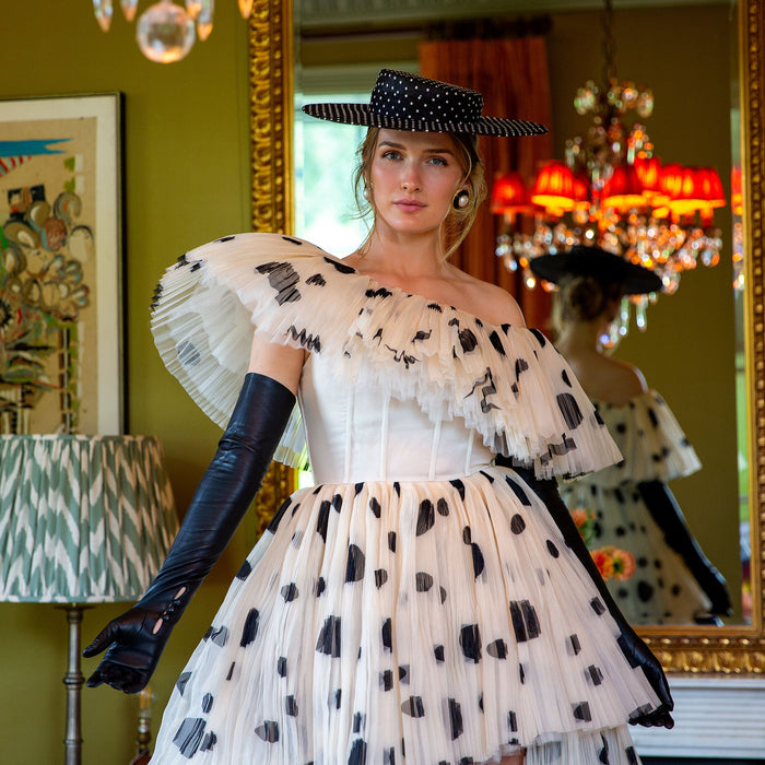 Woman wearing long leather gloves in black with a polka dot dress at a party