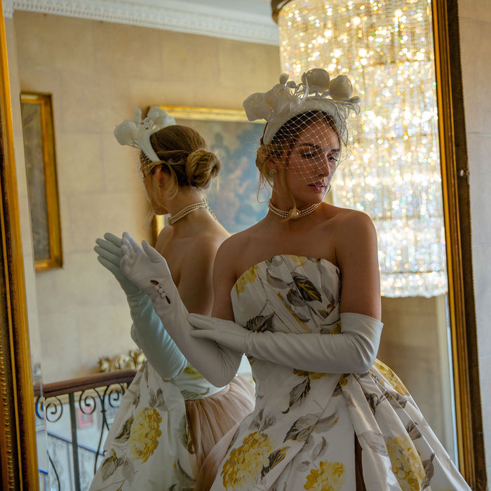 Woman wearing long opera leather gloves in white at a party