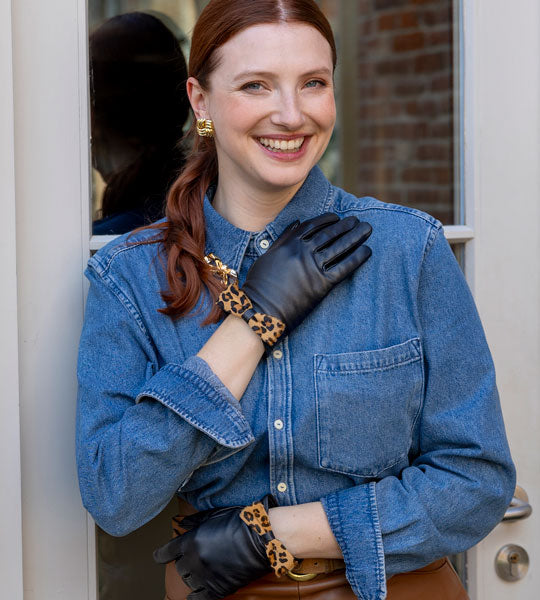 woman wearing leather gloves in black with a leopard print bow