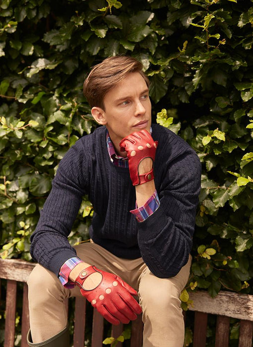 Man wearing red gloves sat on a bench at the park
