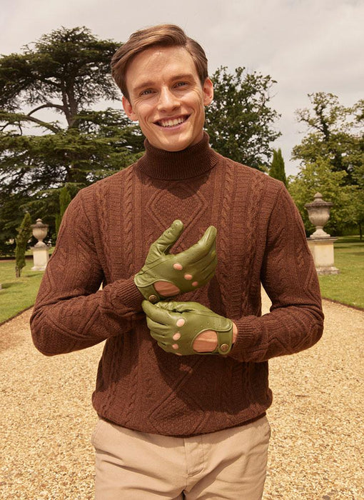 Man wearing green leather driving gloves at a country park 