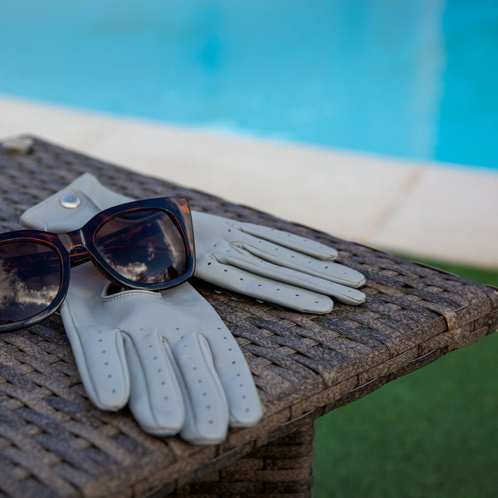 Women's Lined Leather Driving Gloves Dove Grey on a table